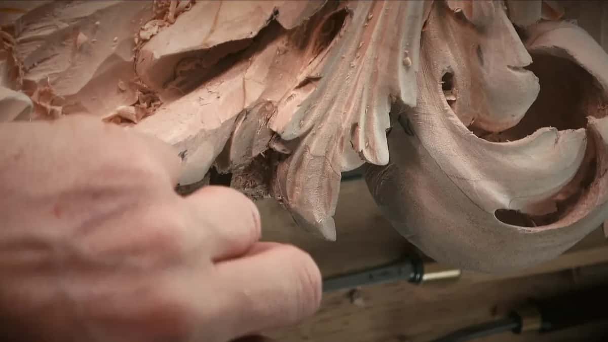 A loose strand of fibre still hanging in the hollow of a carved flower.