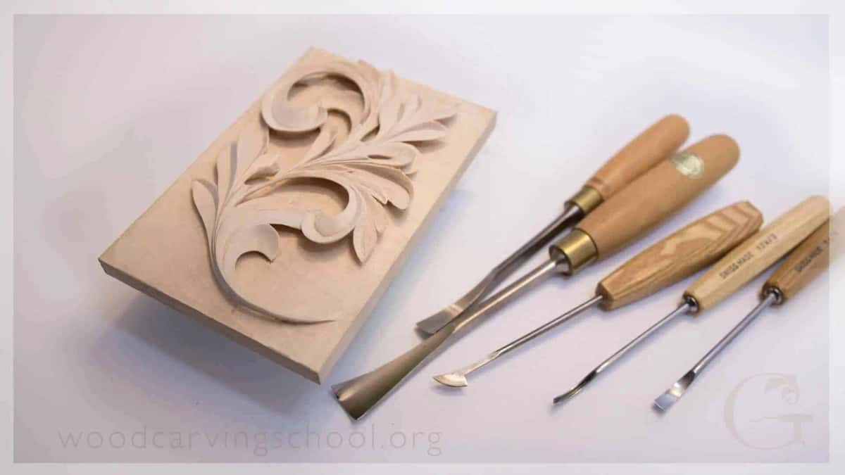 Carved acanthus scroll panel laid out beside the five tools that shaped it