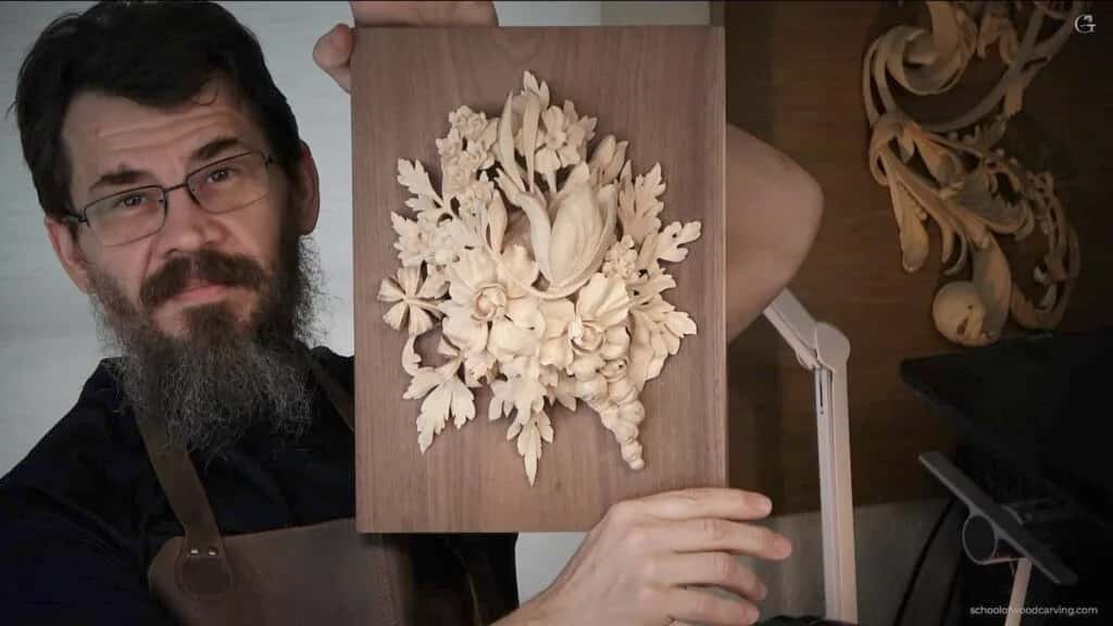 Alexander Grabovetskiy holding a floral panel carved into walnut
