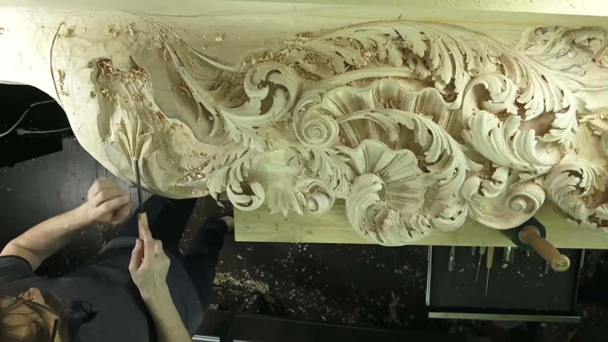 Overhead view of a gouge shaping a Baroque acanthus frieze in basswood
