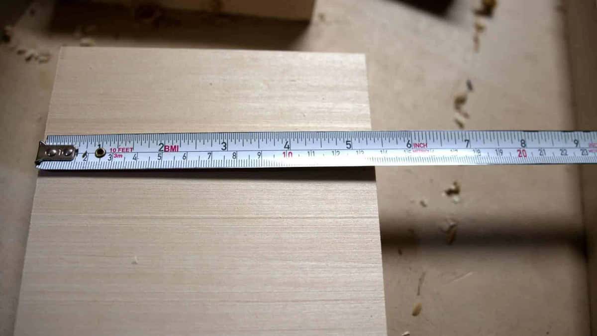 Measuring a basswood rosette blank with a steel tape measure