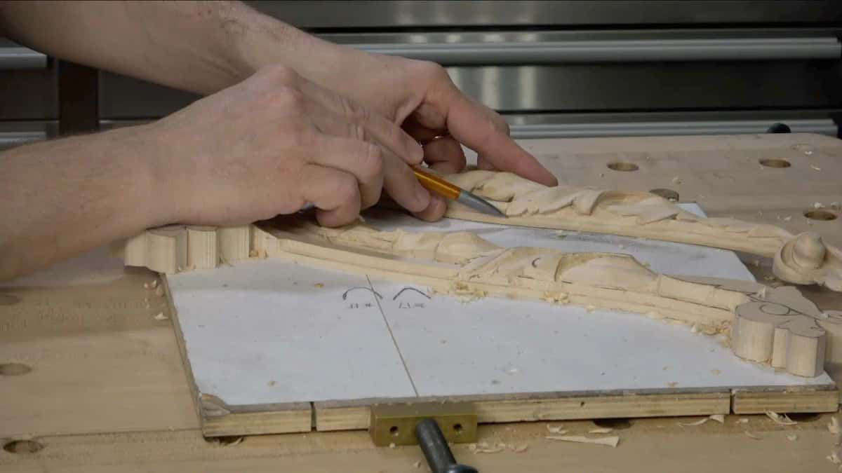A pencil putting the detail lines back onto the roughed out ornament after the waste is gone