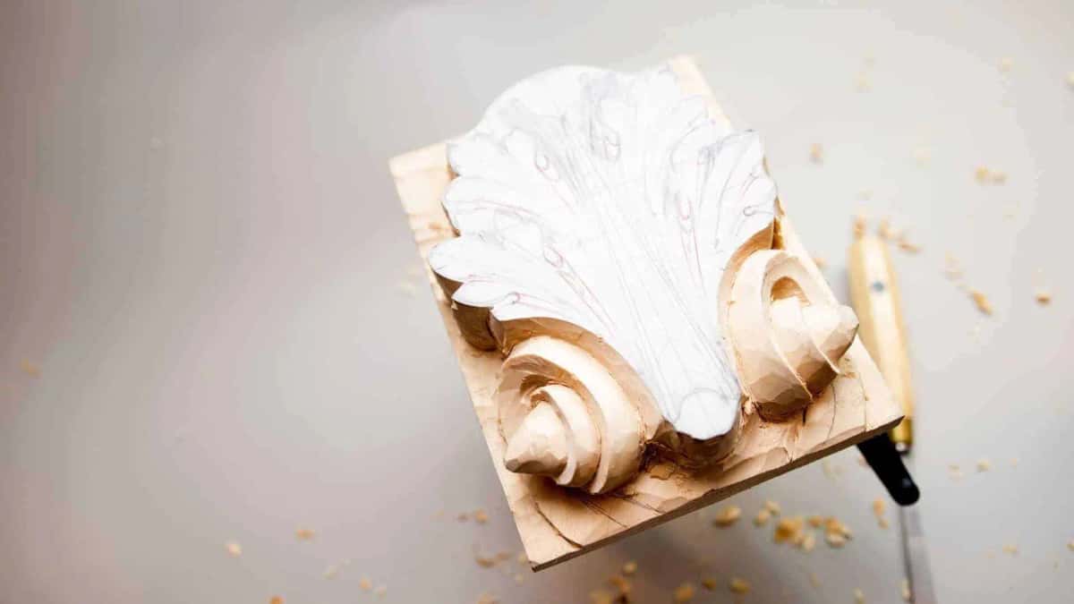 Rounding the bottom volute Bottom volute rounded over while paper still covers the leaves above it, chips gathered at the near corner