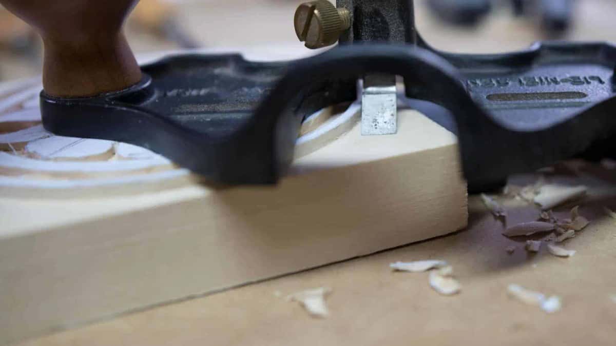 Router plane leveling a rosette background, shavings all around it