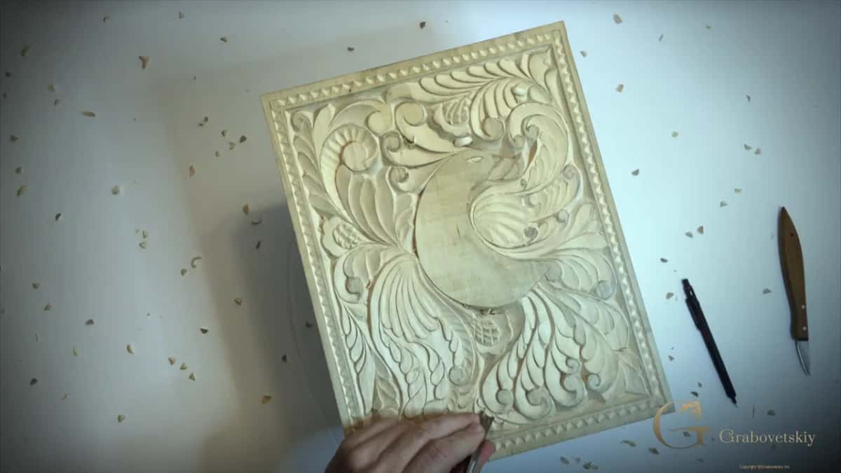 The finished pale panel with its beaded border, a pen and a carving knife on the white top.