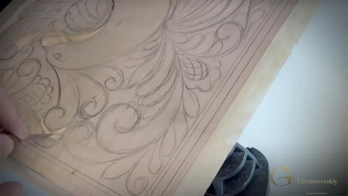 A full pencil design covers a pale board and the first leaf tip has been carved away.