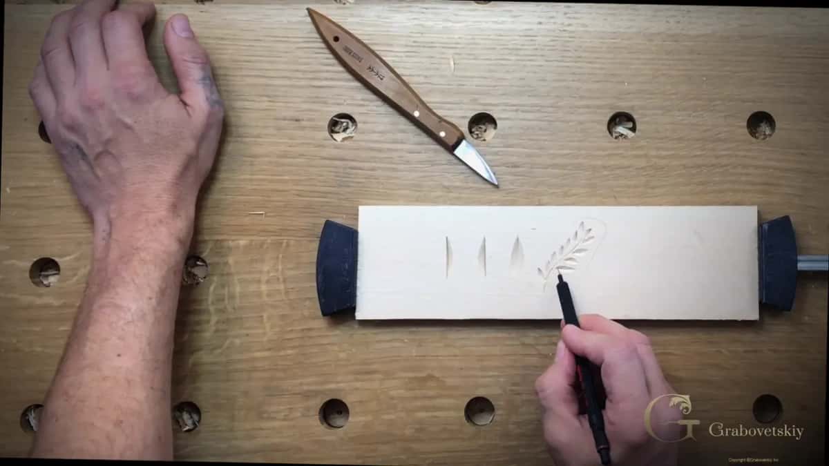 Top-down view of a practice board between two bench dogs, three nicks carved, the knife laid above it.