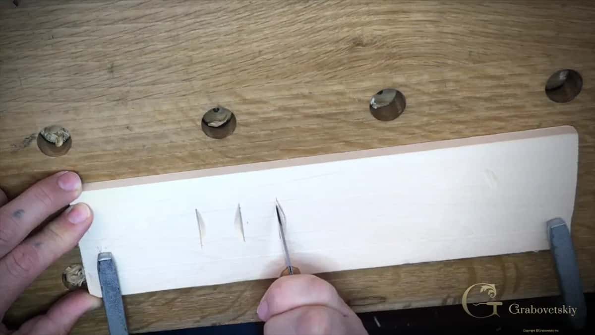 Two clean chips already lifted from the practice board with the knife starting the third angled cut
