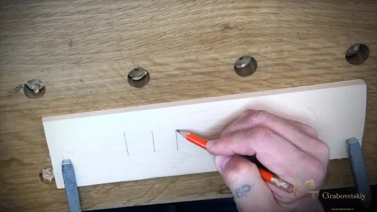 Lines drawn freehand across a basswood practice board with no ruler, the first step in learning to carve