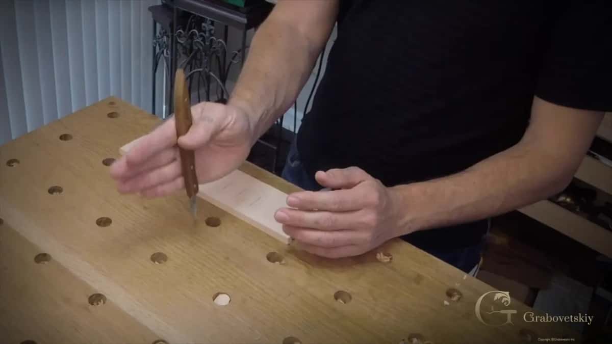 Carving knife handle gripped down into the palm with the blade turned toward the body for a stop cut
