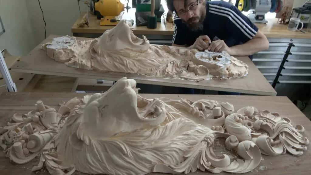 Two basswood panels carved with lion heads among acanthus foliage, one finished and the other still in the rough