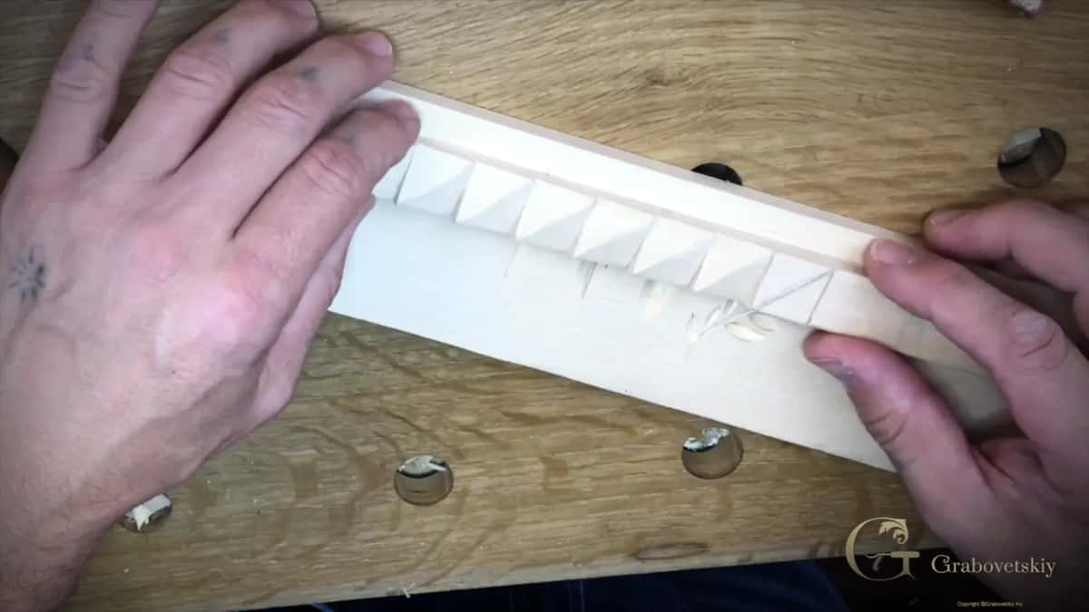 Finished hand carved basswood molding held in both hands so the shadow shows how deep each cut goes