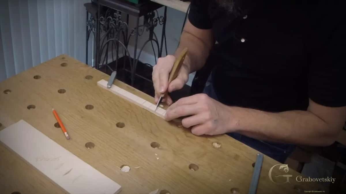 Narrow basswood strip clamped down and marked off in equal steps for a beginner molding project