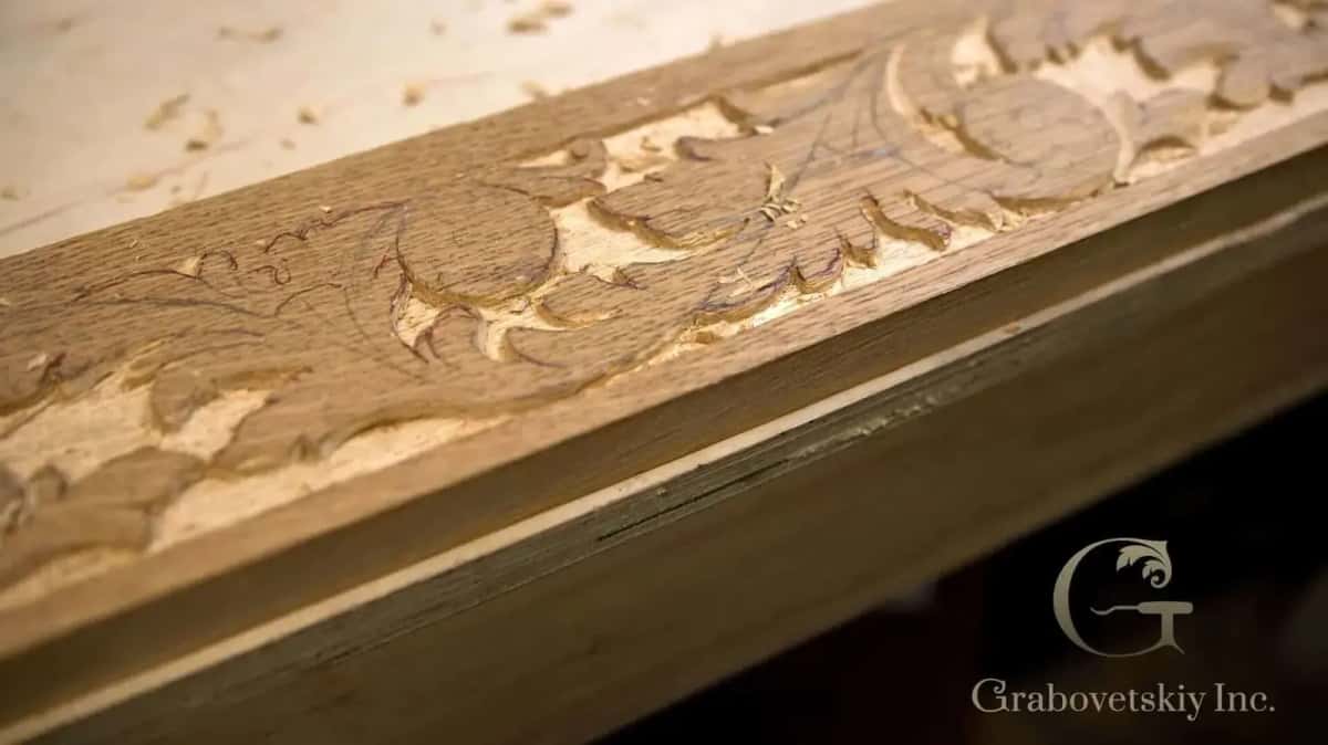 A carved molding on a piece of furniture, the pencil lines still visible inside the cuts