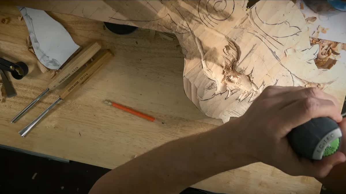 Round black handle pressed down over the carving