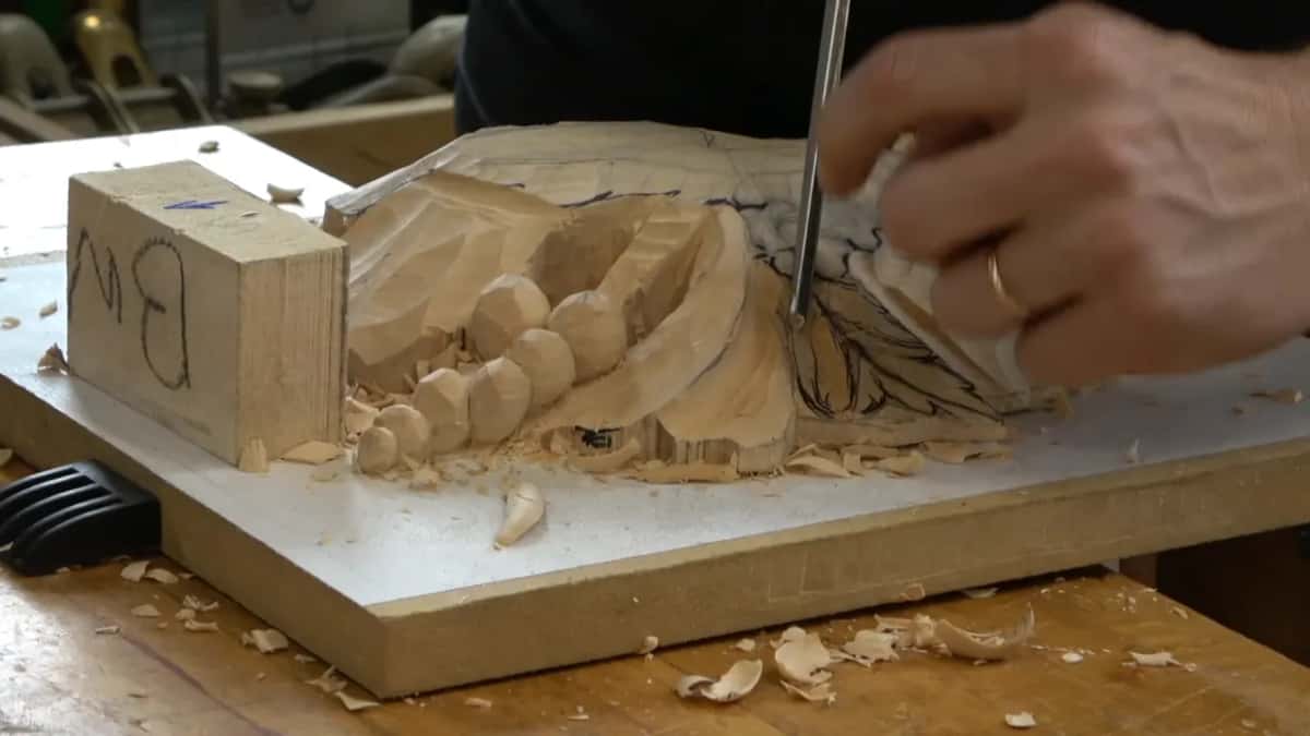 Alexander holding the narrow gouge up so the camera can see the hollow running down the blade