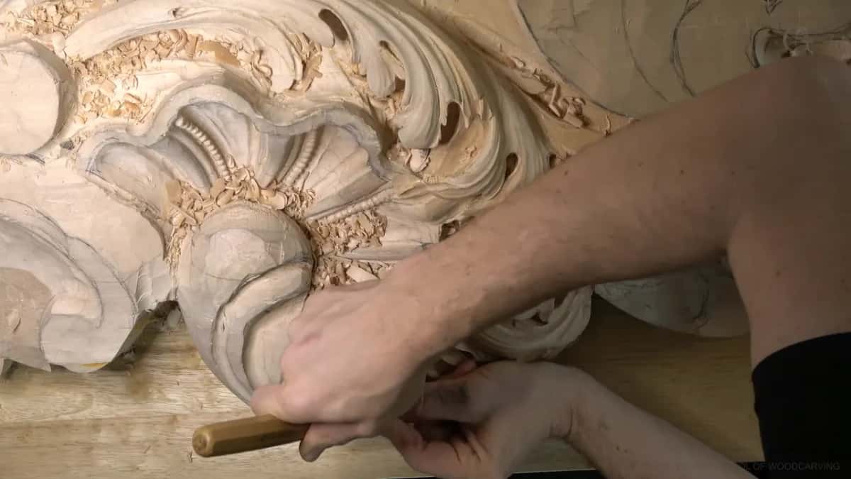 Both hands steer a long gouge under the lower lobe from below.