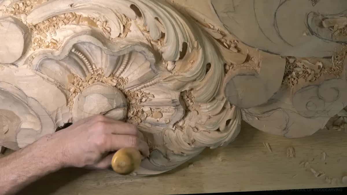 A round wood handle in his fist, the edge working the curve of the big chunk.