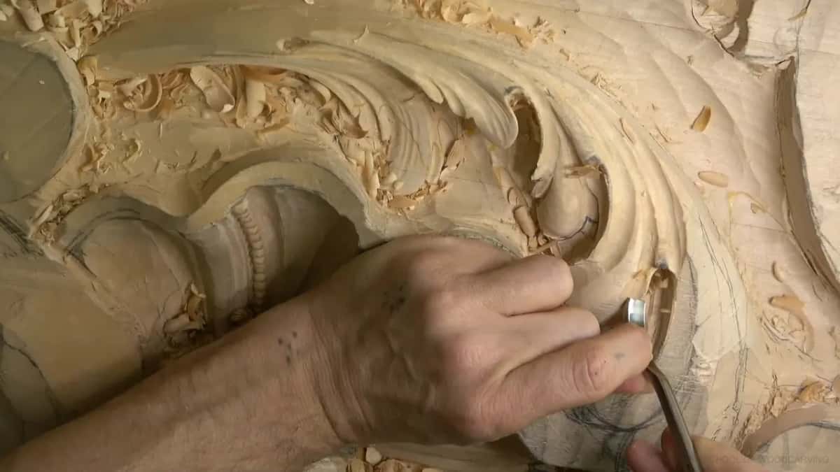 Fingers wrap a bent gouge and ease it along the outer edge of a lobe.