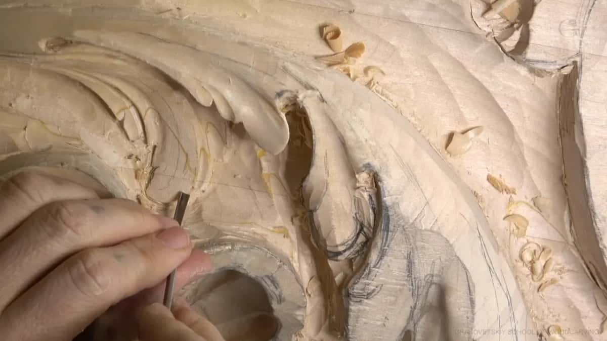 Tiny gouge, held almost upright.