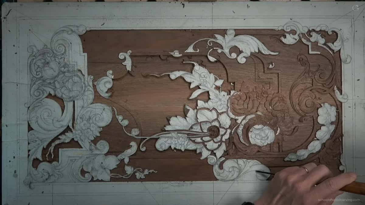 Overhead view of the drawing on the board, most of it still chalk, one hand at the edge.