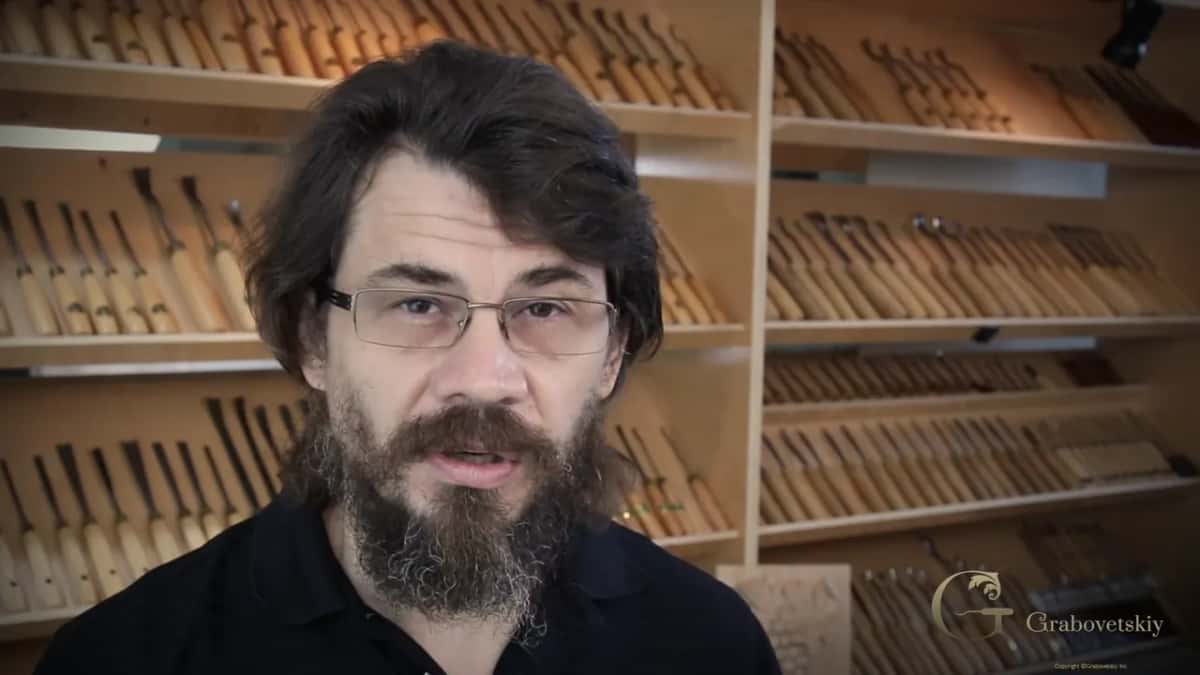 Talking straight to camera about talent that never got used, a rack of carving tools filling the wall behind him