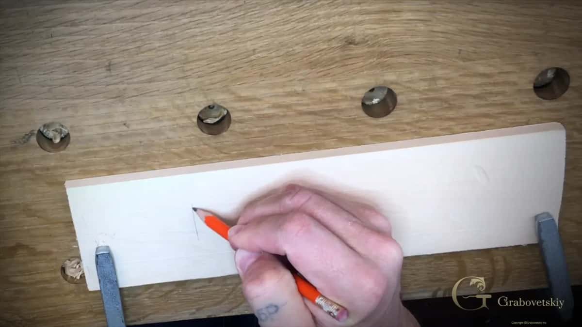 Three straight pencil lines being drawn across the board with an orange pencil