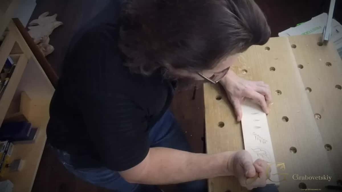 Working along the board from above, one hand steadying and one cutting