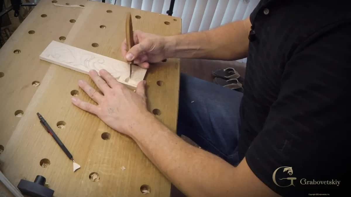Cutting into the design with a hand pressed flat beside it