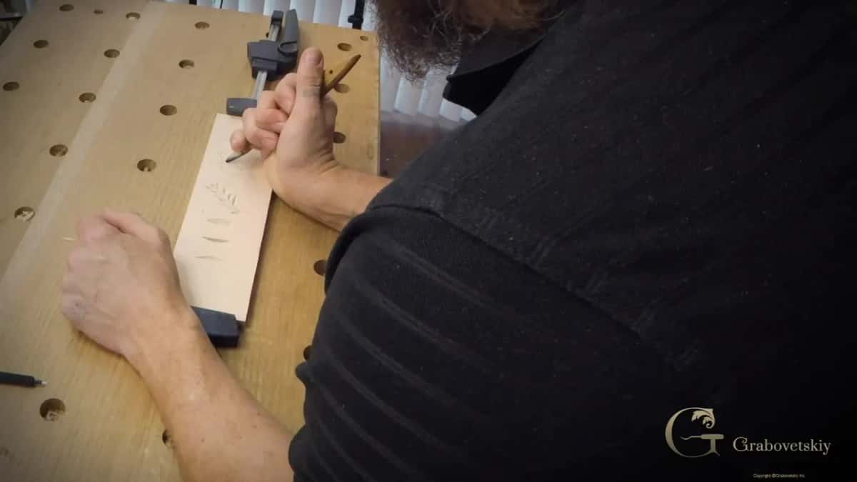 Leaning over the clamped board with the tool in hand