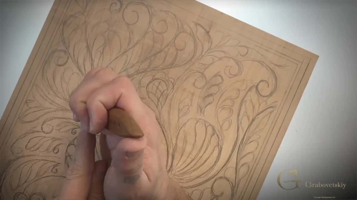 A spiral curl taking shape under the knife beside the wing, the shape books call a volute.