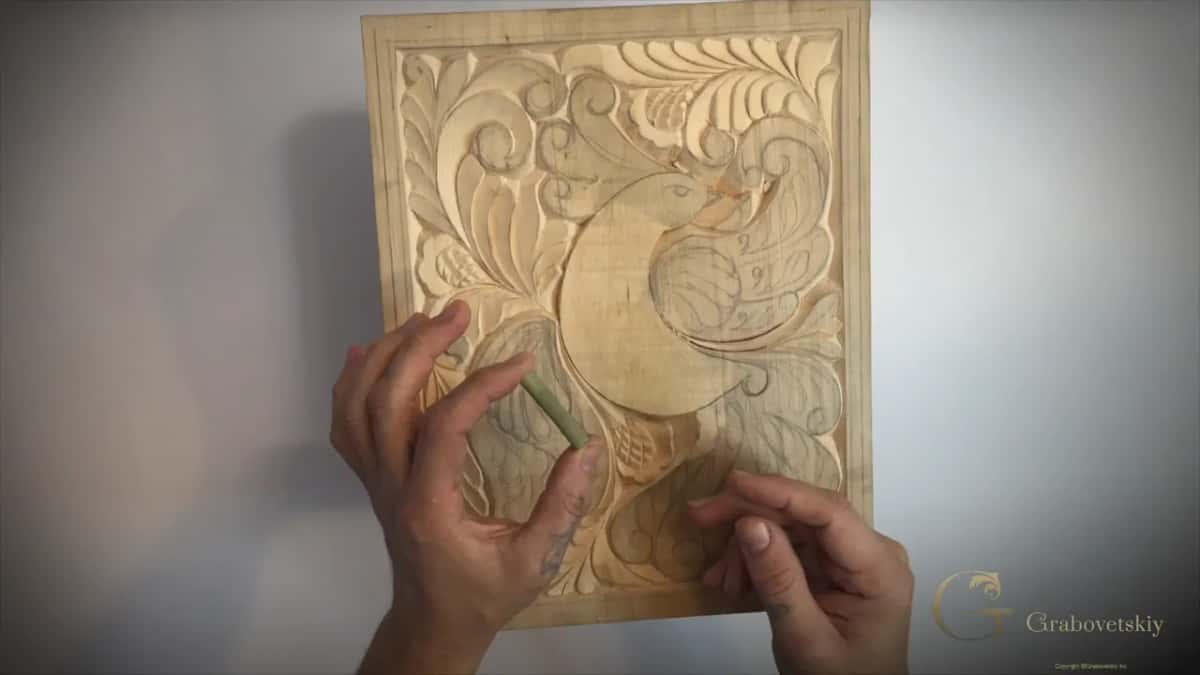 A short green stem of Dutch rush held against the carved panel.