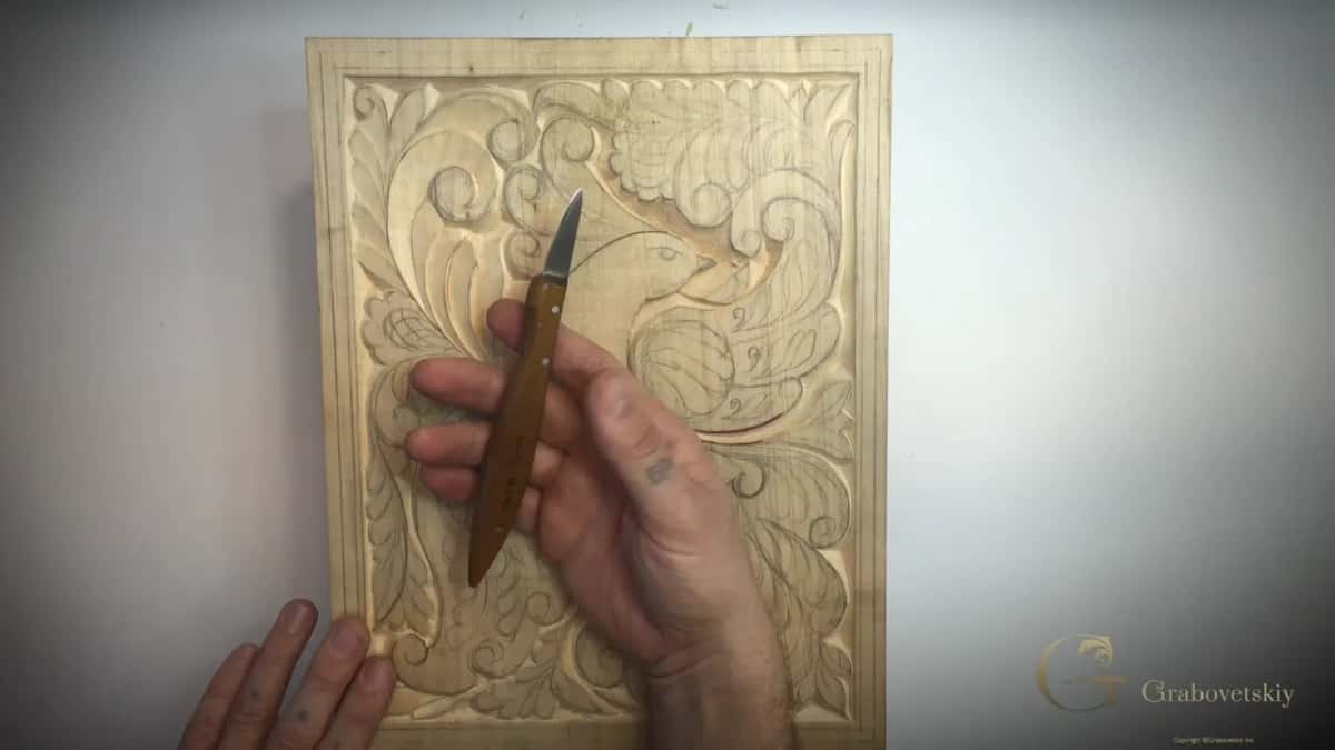 The Swiss made number 12 chip carving knife, held over the panel it has carved.