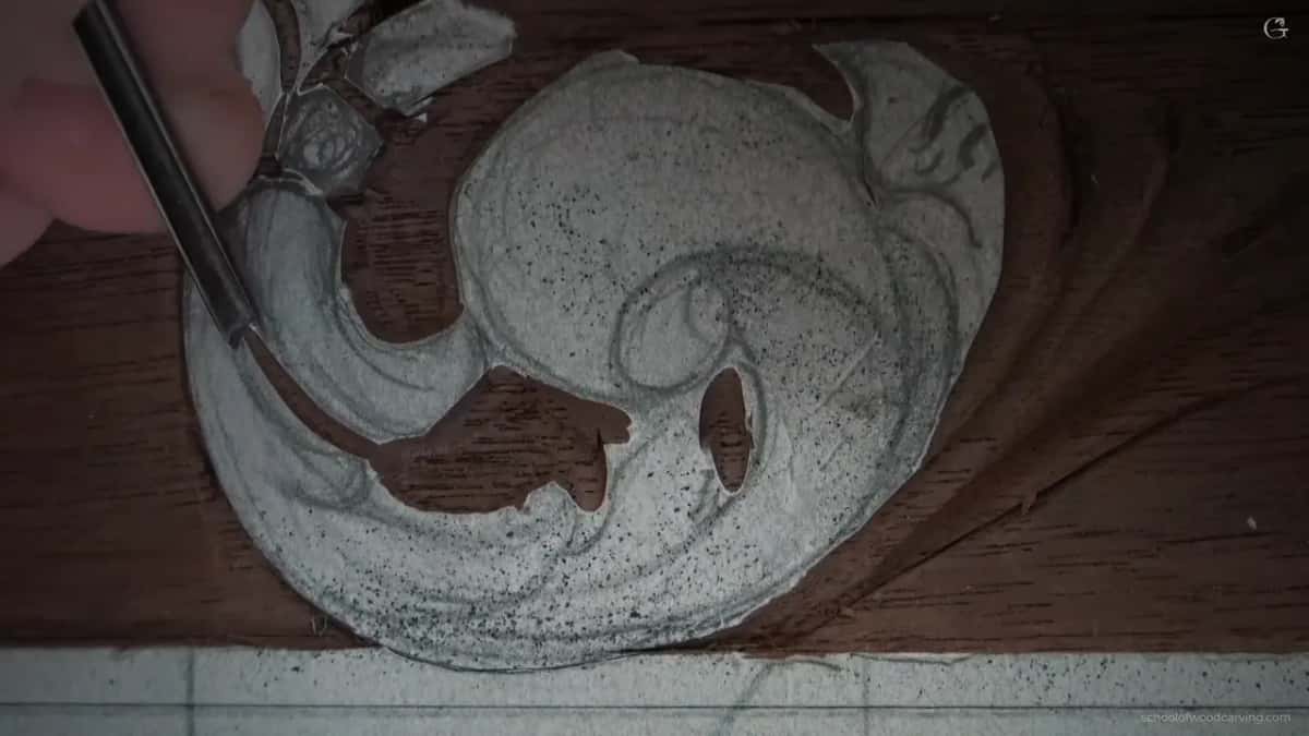 Slim dark shaft running along the edge of the carved scroll right here.