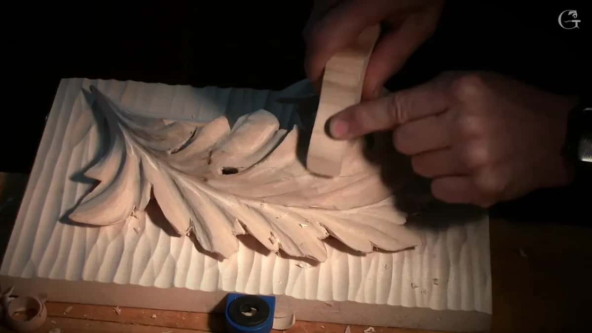 Chip of wood held against a Byzantine acanthus leaf, ready to rub it