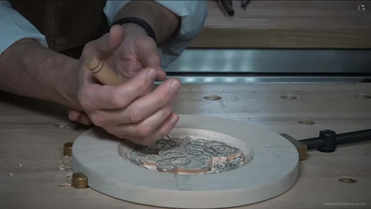 Two brass bench dogs beside the plate as the knife starts