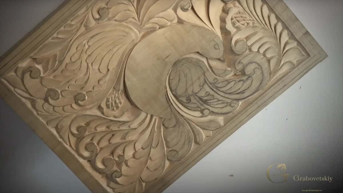 Whole board at a low angle, every curl running into the next, pencil still showing where the carving has not reached.