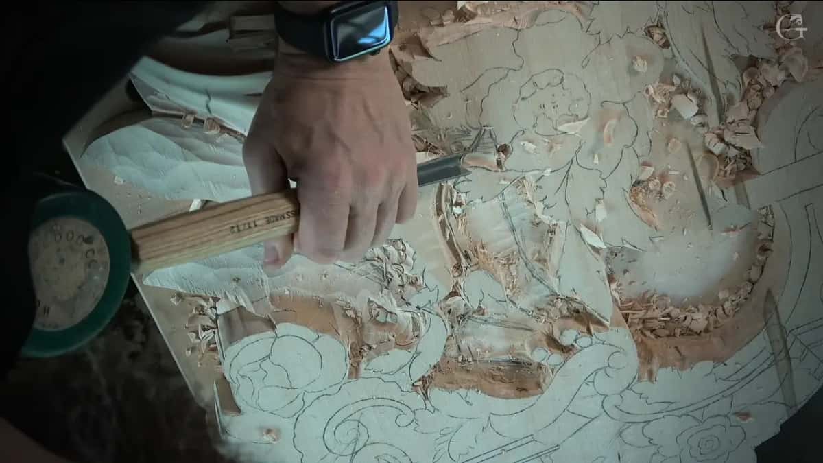Light handle gripped in a fist, green mallet head resting in the lower corner