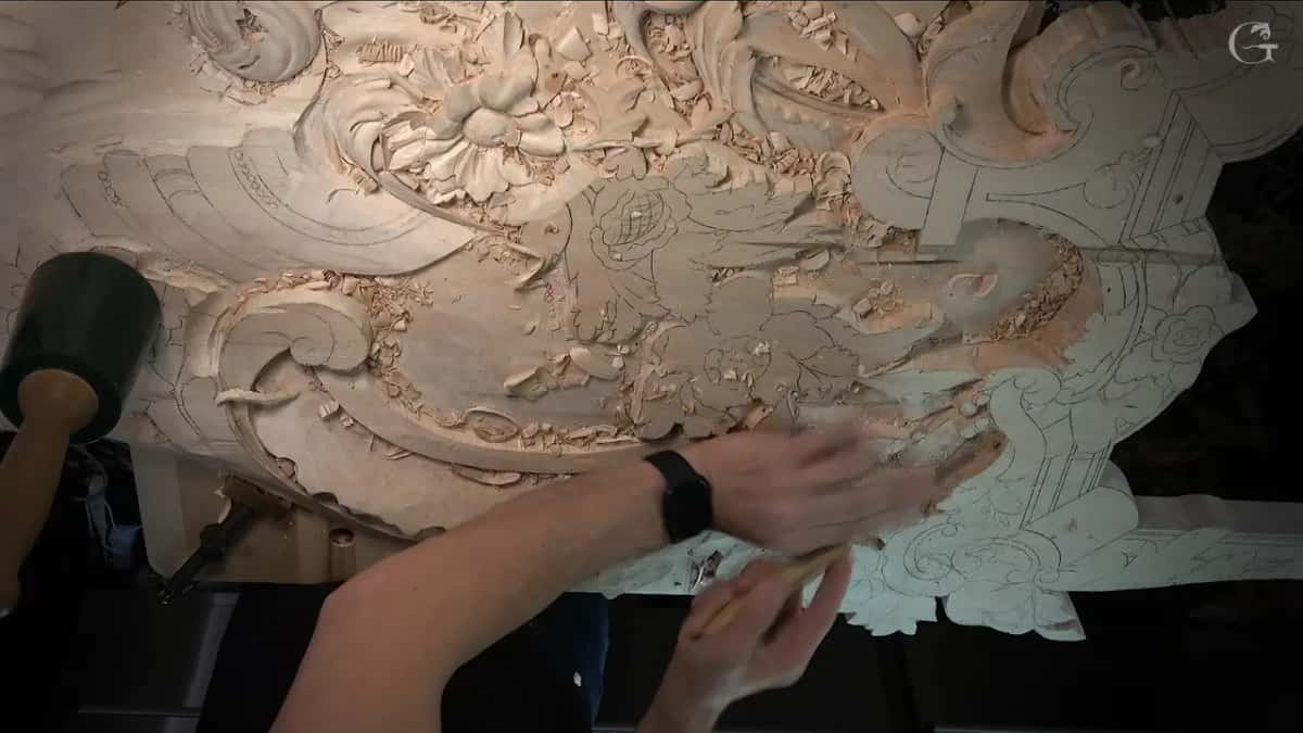 Whole panel from above, carved flowers up top, pencil leaves still flat below, a mallet parked on the left