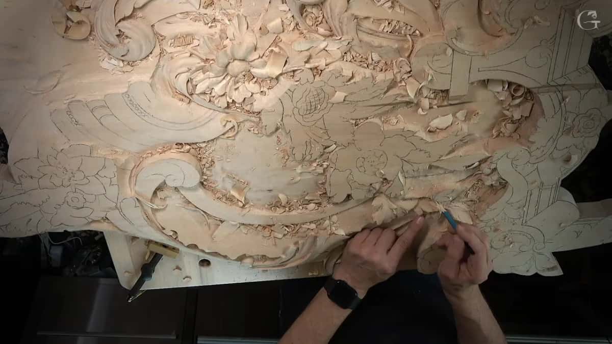 Seen from above, a blue pencil touches the wood near the edge while the left hand rests on it