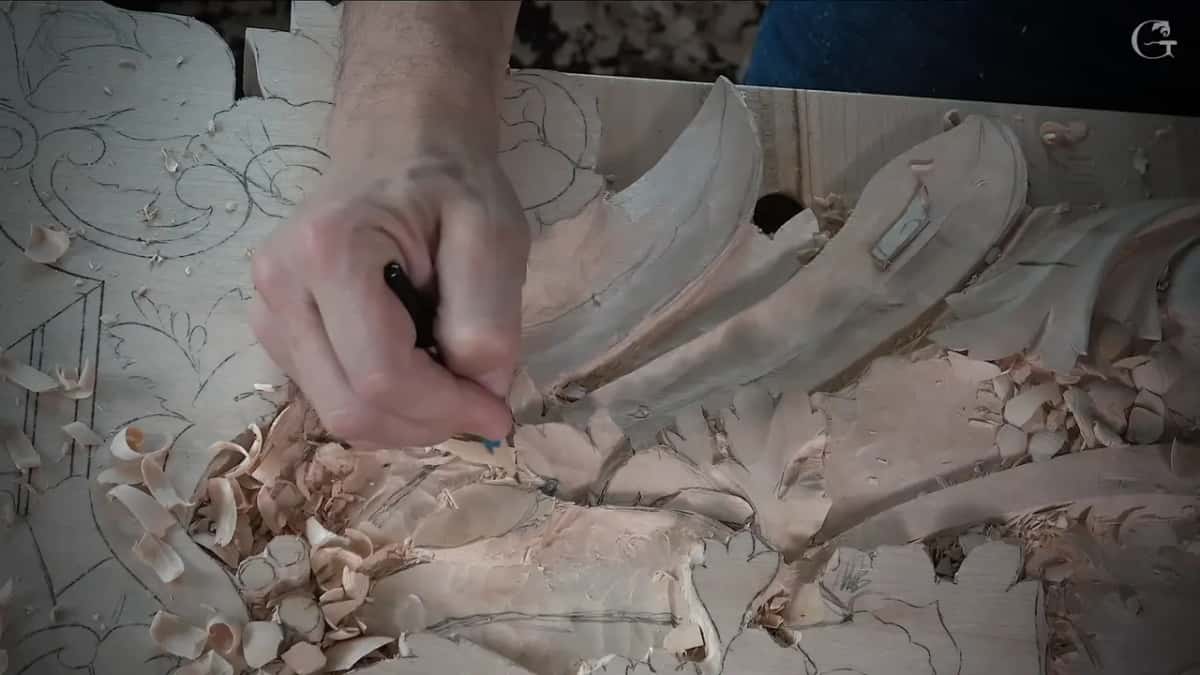 Pencil tip drawing a fresh line across one roughed leaf, chips below it