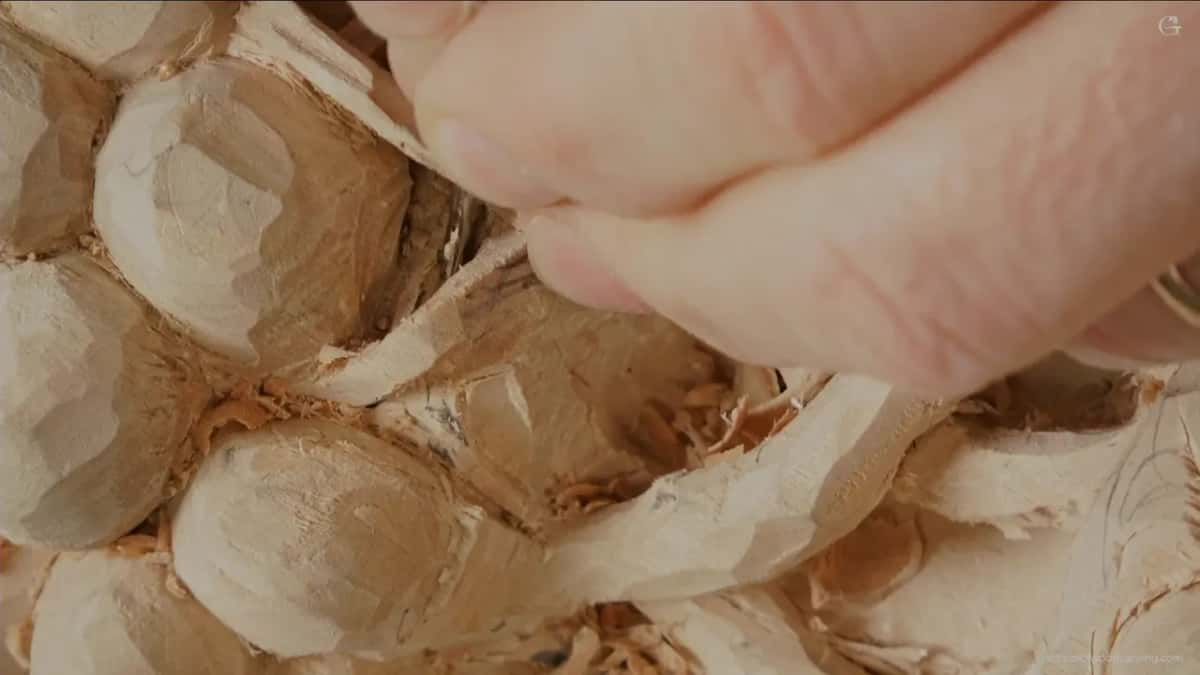 Fingers taking the load instead of the carving, with the blade lying across one knuckle