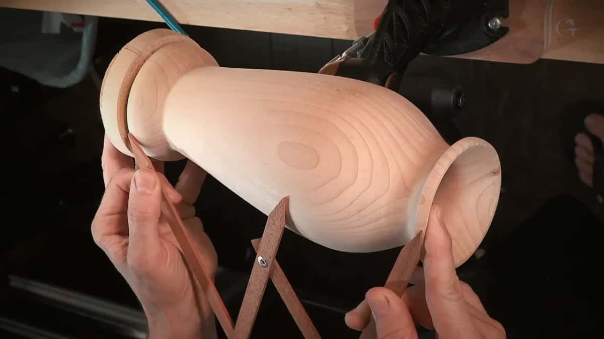 Golden ratio calipers open against the vase, middle leg landing on the widest part