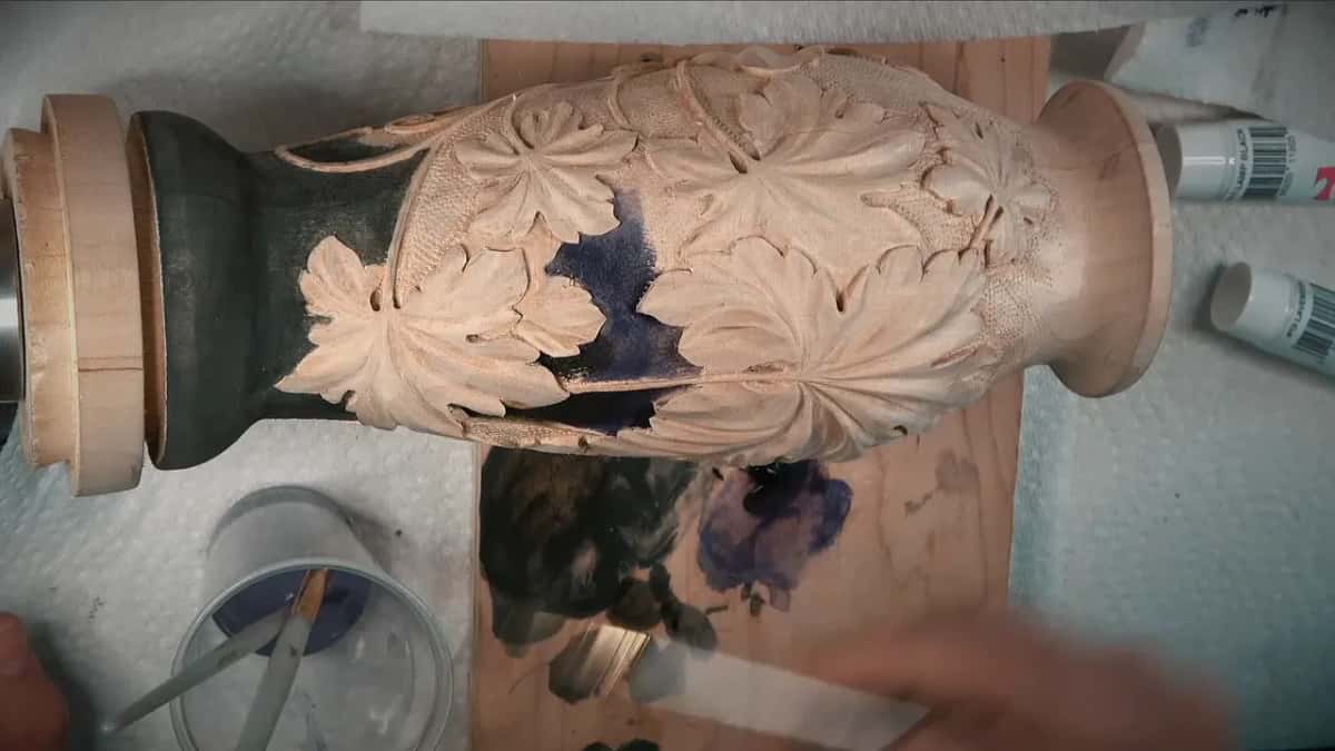 Purple wash going in between the leaves, a jar of it at the corner of the bench