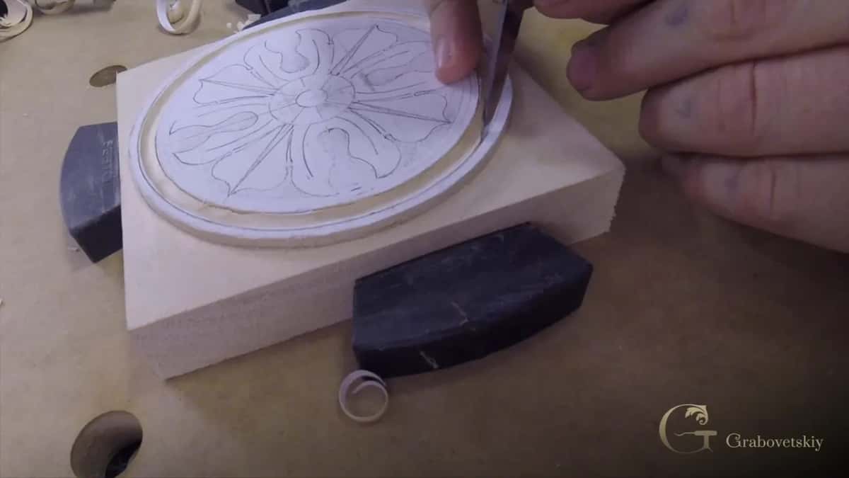 Both hands on the block with the ring cut and the waste already out of it