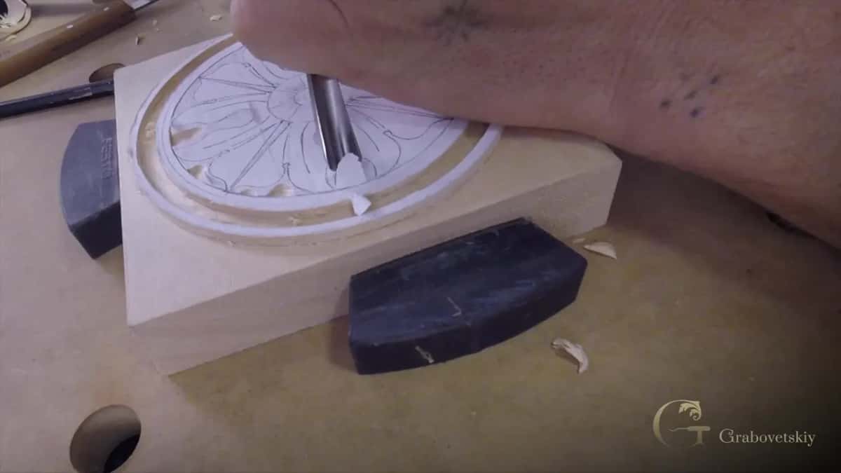 Edge of the tool set down beside the drawn shape rather than on it, forearm braced