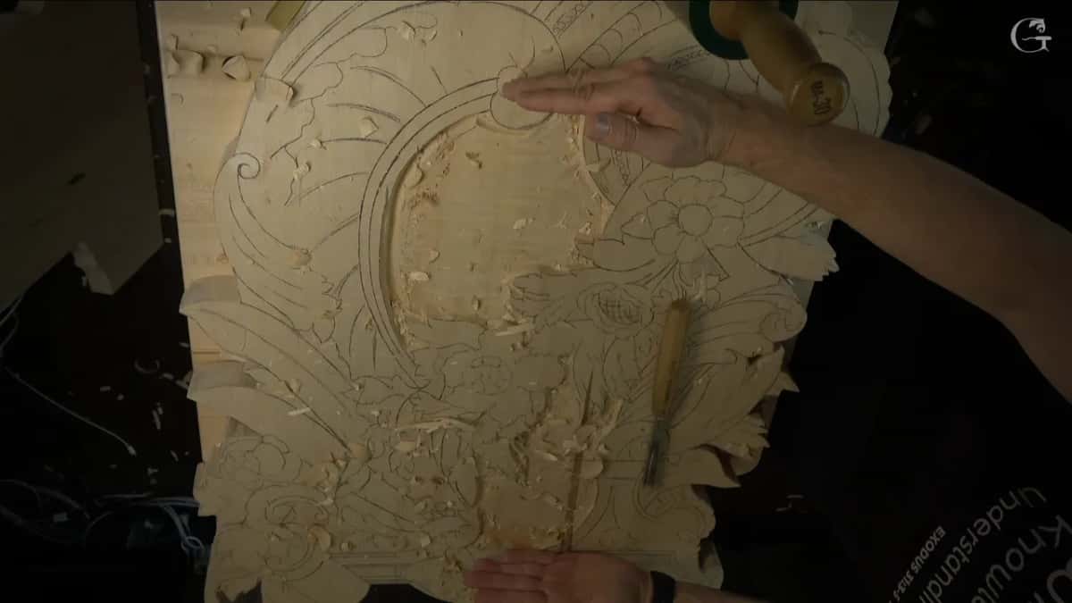Roughed panel covered in pencil design lines, with a green mallet and one gouge lying where the field has been lowered