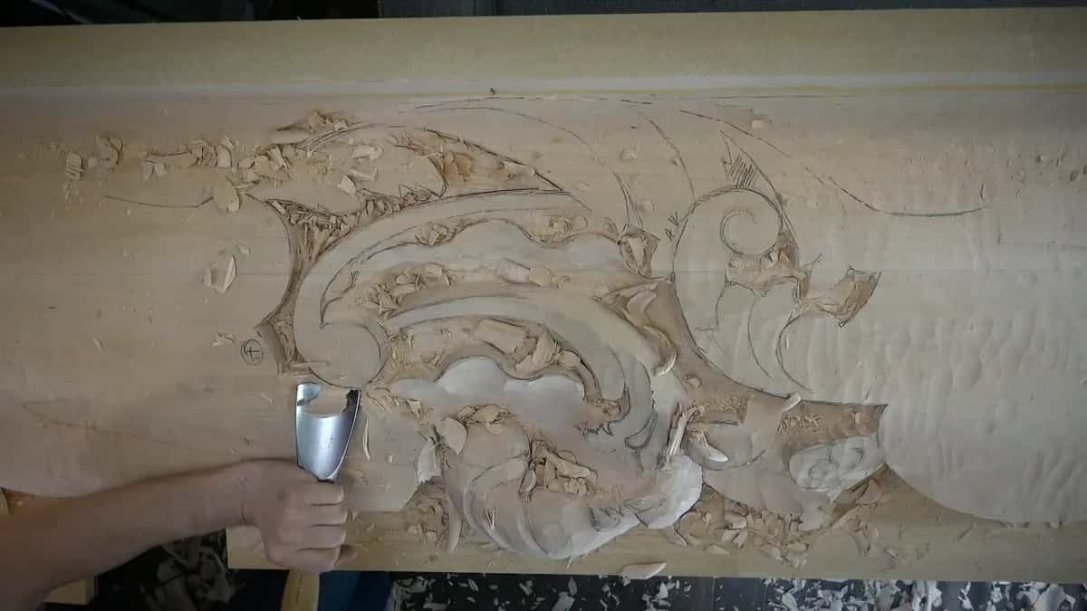 A wide shiny gouge enters the left side of the carving.
