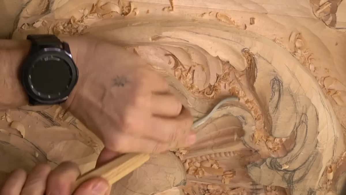 Two hands work a spoon gouge in beside the shell's beads.