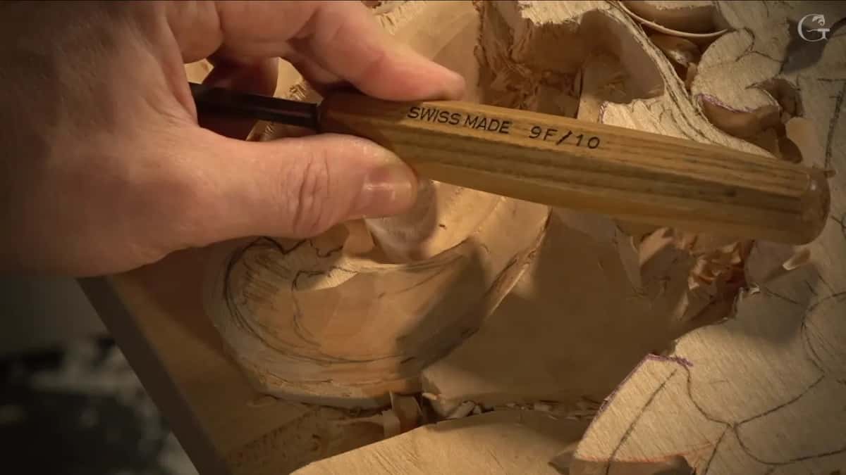 Fingers hold a handle stamped SWISS MADE 9F/10.